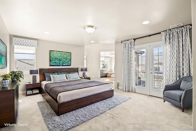 bedroom with light colored carpet, access to outside, and french doors