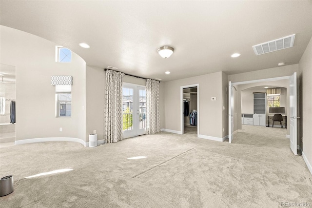 interior space featuring lofted ceiling, light colored carpet, and french doors