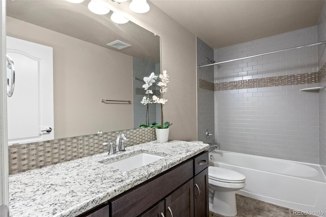 full bathroom with backsplash, vanity, tiled shower / bath combo, and toilet