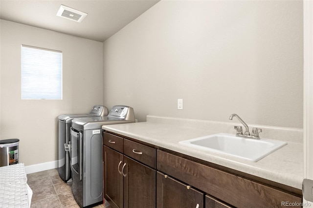 washroom featuring light tile patterned floors, sink, independent washer and dryer, and cabinets