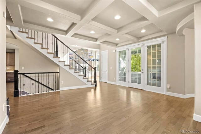 unfurnished living room featuring wood-type flooring, beamed ceiling, and coffered ceiling