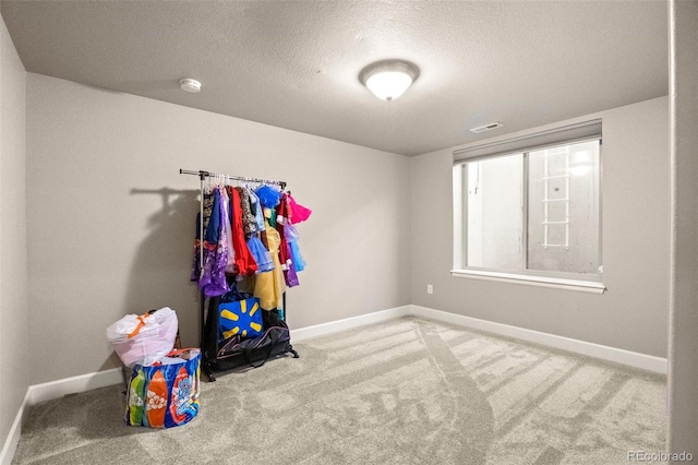 game room with a textured ceiling and carpet flooring