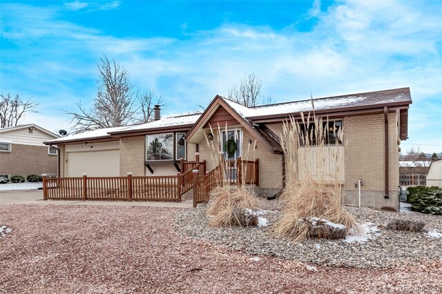 rear view of property with a garage, brick siding, and concrete driveway