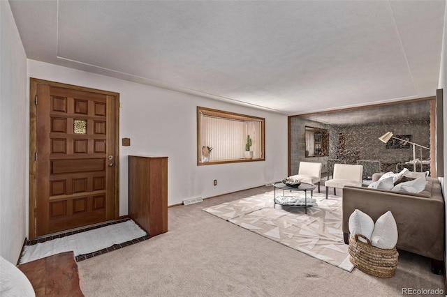 living area with visible vents and carpet
