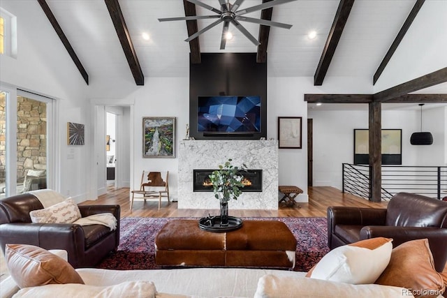 15116 Lyons Ridge Dr, Morrison, CO 80465 - living room with vaulted ceiling with beams, a glass covered fireplace, wood finished floors, and ceiling fan