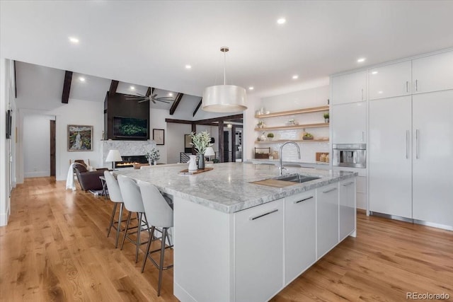 15116 Lyons Ridge Dr, Morrison, CO 80465 - kitchen with a ceiling fan, open shelves, a spacious island, a sink, and white cabinets