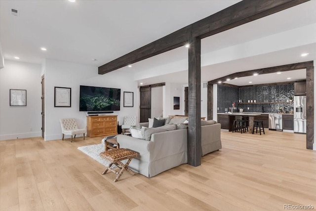 15116 Lyons Ridge Dr, Morrison, CO 80465 - living area with beam ceiling, baseboards, light wood-type flooring, recessed lighting, and bar area