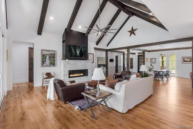 15116 Lyons Ridge Dr, Morrison, CO 80465 - living area featuring a ceiling fan, beam ceiling, baseboards, light wood finished floors, and a glass covered fireplace