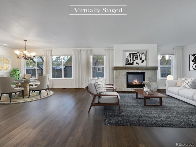 living room with a tiled fireplace, a chandelier, and dark hardwood / wood-style flooring