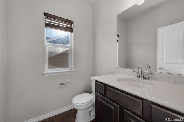 bathroom featuring toilet, vanity, and hardwood / wood-style flooring