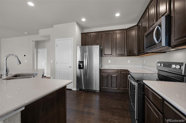 kitchen with sink, dark hardwood / wood-style floors, dark brown cabinets, and appliances with stainless steel finishes