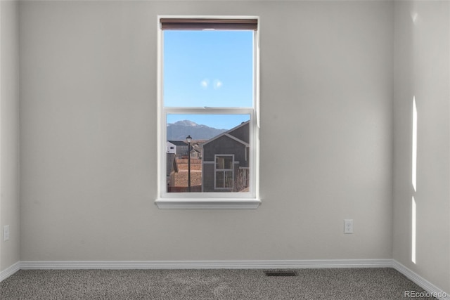 empty room with a mountain view and carpet floors