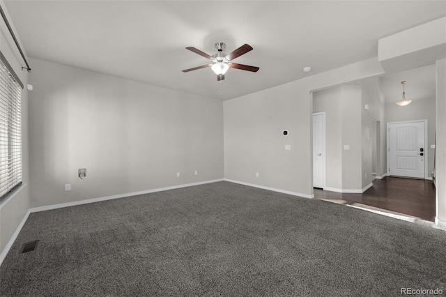 unfurnished room with ceiling fan and dark carpet