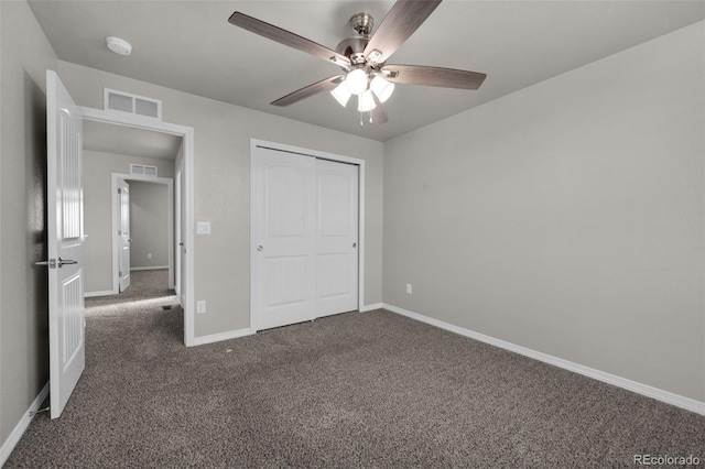 unfurnished bedroom with dark colored carpet, ceiling fan, and a closet