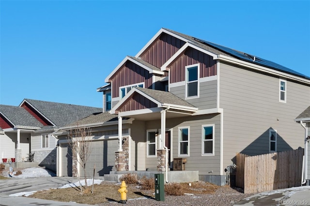 6677 Lamine Dr, Colorado Springs, CO 80925 - craftsman-style house with fence, driveway, solar panels, a garage, and board and batten siding