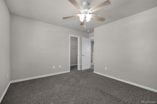 6677 Lamine Dr, Colorado Springs, CO 80925 - unfurnished bedroom with baseboards, ceiling fan, a closet, a walk in closet, and dark colored carpet