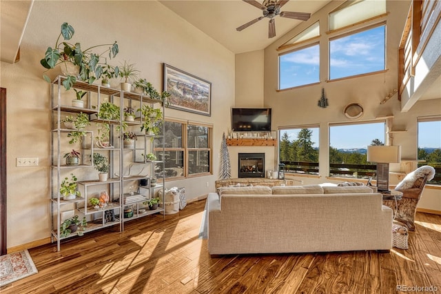 living room with ceiling fan, hardwood / wood-style flooring, and high vaulted ceiling