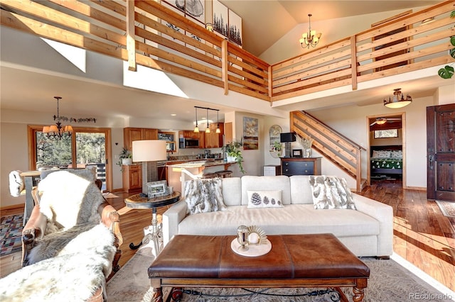 living room with high vaulted ceiling, dark wood-type flooring, and a chandelier