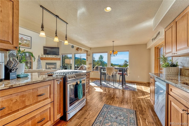 kitchen featuring a textured ceiling, a chandelier, pendant lighting, and stainless steel range with gas stovetop