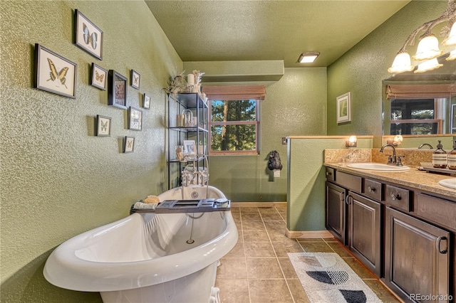 bathroom featuring a textured ceiling, tile patterned floors, a bath, and vanity