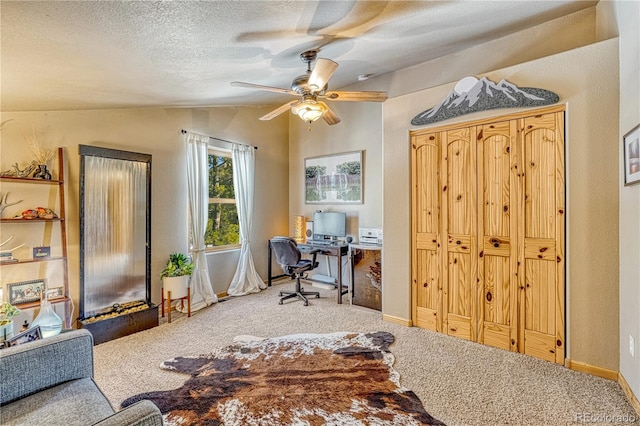 home office with vaulted ceiling, ceiling fan, carpet flooring, and a textured ceiling