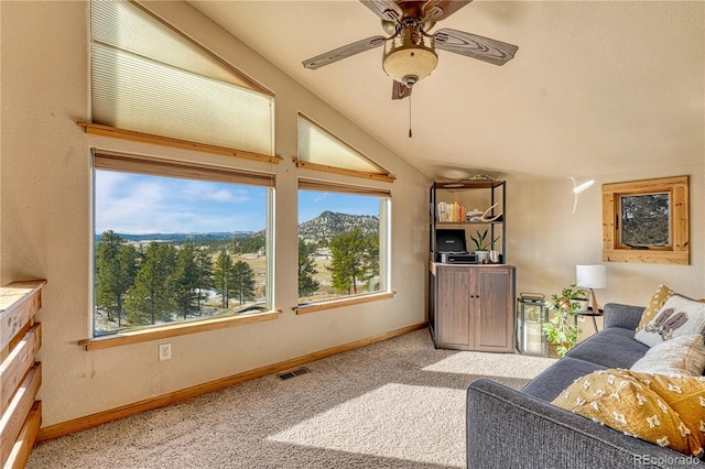 carpeted living room featuring ceiling fan and lofted ceiling