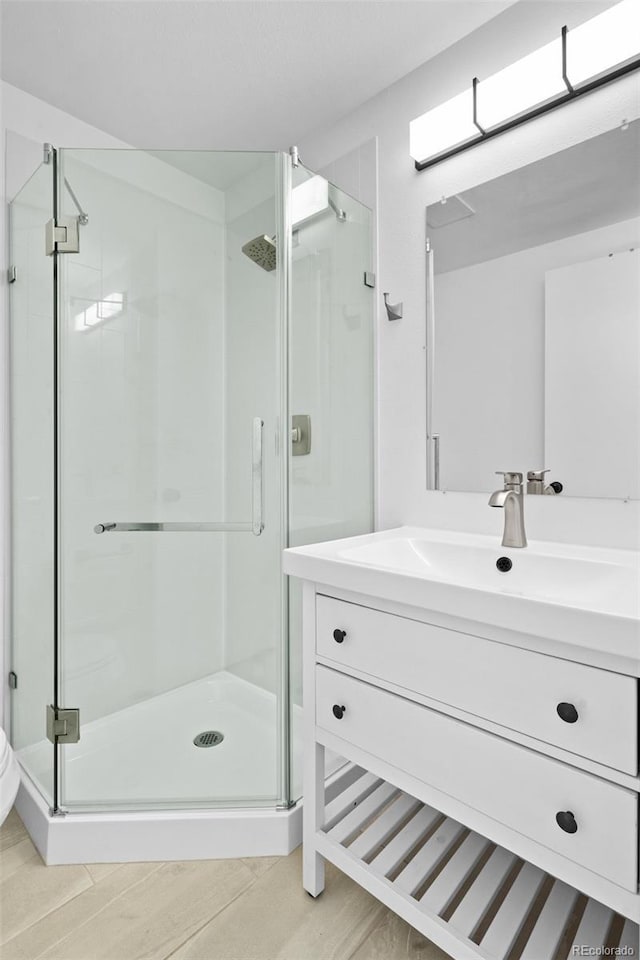 3541 W 17th Ave, Denver, CO 80204 - bathroom with a stall shower, vanity, and wood finished floors