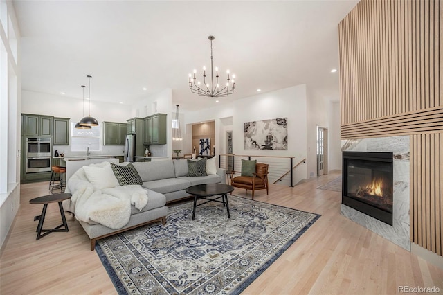 7410 Winter Berry Ln, Castle Pines, CO 80108 - living room with light wood-type flooring, a chandelier, recessed lighting, and a premium fireplace