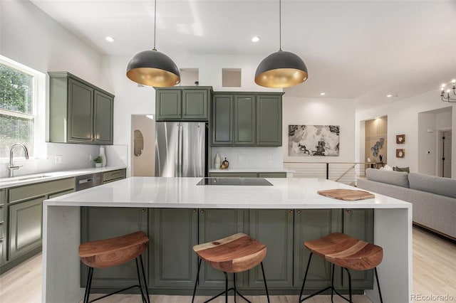 7410 Winter Berry Ln, Castle Pines, CO 80108 - kitchen with freestanding refrigerator, green cabinetry, backsplash, light wood-style flooring, and black electric stovetop