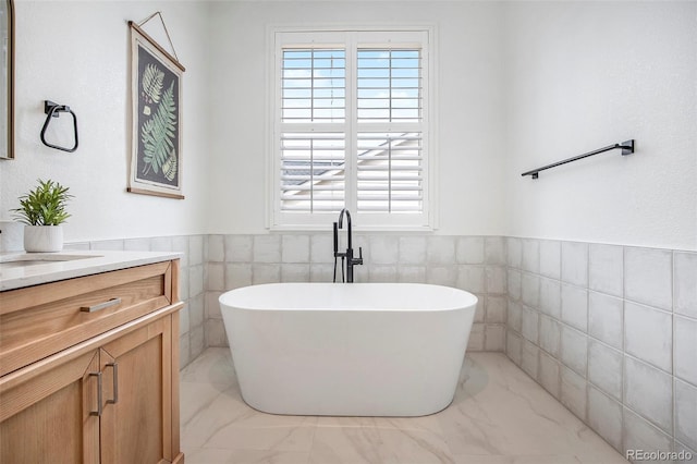 7410 Winter Berry Ln, Castle Pines, CO 80108 - bathroom featuring vanity, marble look tile flooring, a soaking tub, tile walls, and plenty of natural light