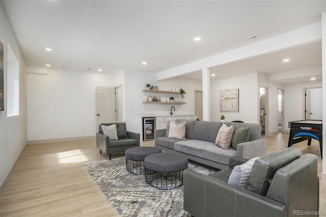 7410 Winter Berry Ln, Castle Pines, CO 80108 - living area featuring bar with sink, wine cooler, light wood finished floors, and recessed lighting