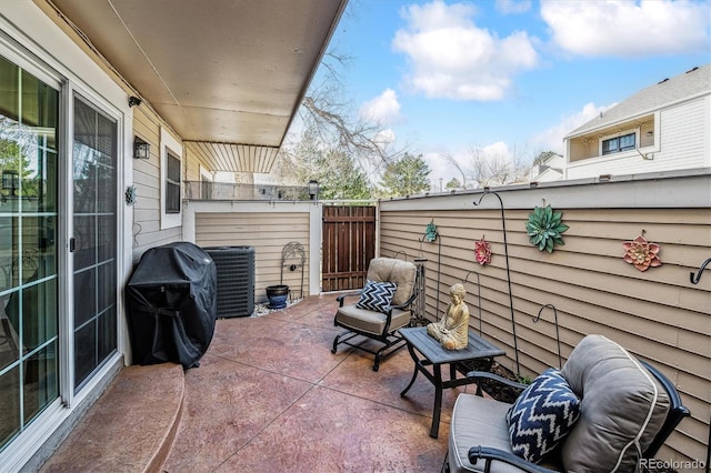 view of patio featuring central AC unit, area for grilling, and fence