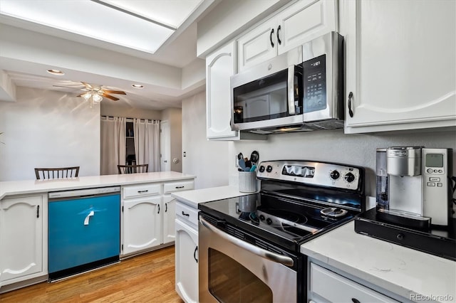 kitchen featuring white cabinets, ceiling fan, stainless steel appliances, light wood-type flooring, and recessed lighting