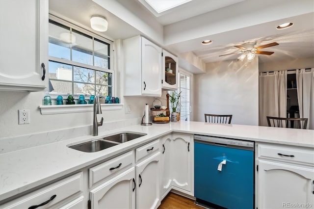 kitchen with a healthy amount of sunlight, white cabinetry, dishwasher, and a sink