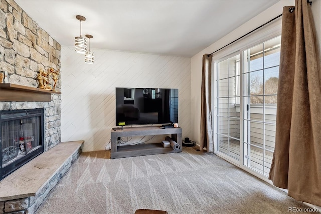 carpeted living room featuring a fireplace and wood walls