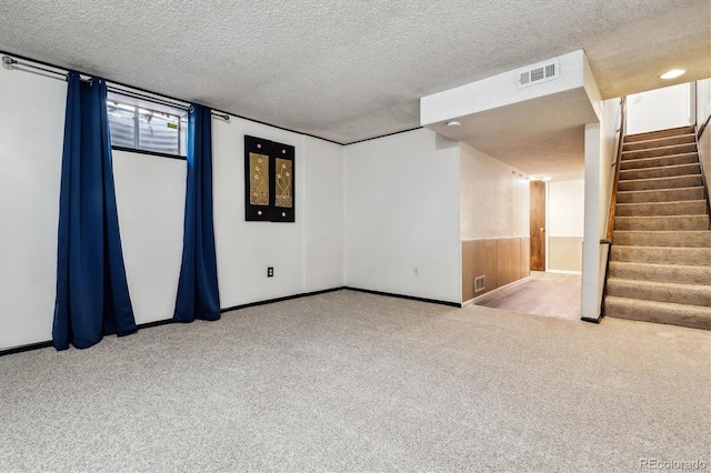 empty room featuring stairs, carpet floors, a textured ceiling, and visible vents