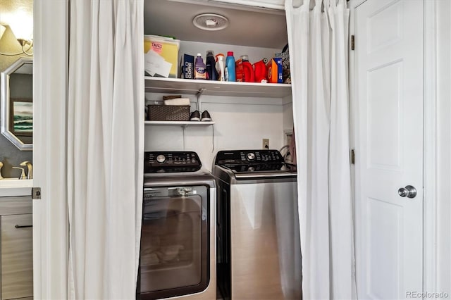 clothes washing area with laundry area, separate washer and dryer, and a sink