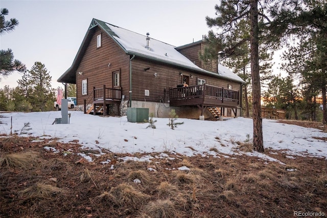 snow covered house featuring a deck