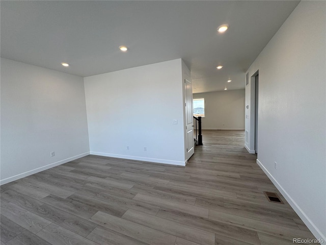 spare room featuring visible vents, recessed lighting, baseboards, and wood finished floors