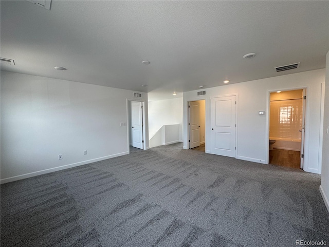 carpeted spare room with visible vents and baseboards