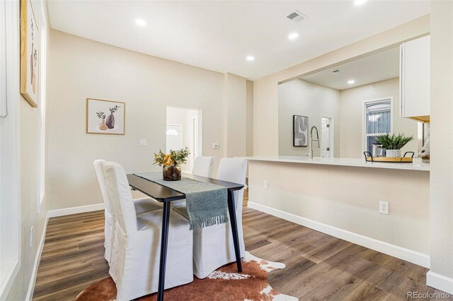 dining area with sink and hardwood / wood-style flooring