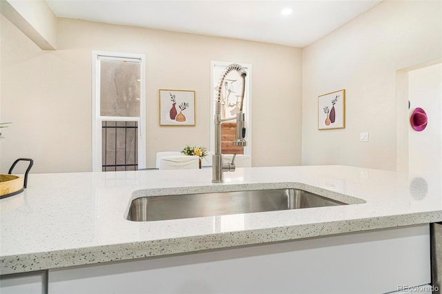 kitchen with light stone countertops and sink