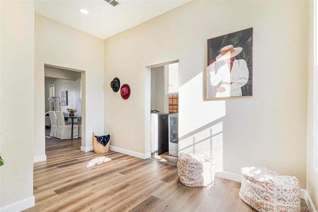 corridor featuring washing machine and dryer and light hardwood / wood-style flooring