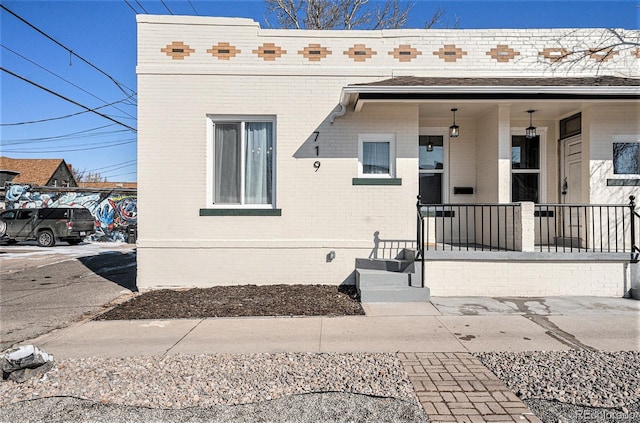 view of front of home with brick siding and a porch