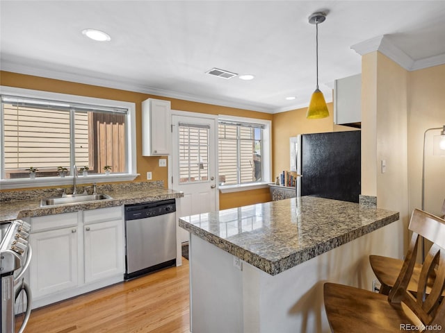 746 Birch St, Denver, CO 80220 - kitchen featuring white cabinetry, appliances with stainless steel finishes, a sink, and light wood-style flooring
