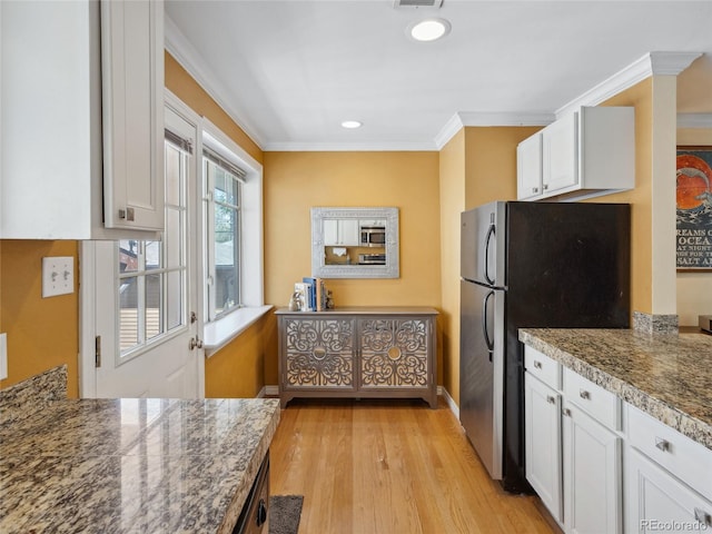 746 Birch St, Denver, CO 80220 - kitchen featuring crown molding, freestanding refrigerator, light wood-style floors, baseboards, and white cabinets