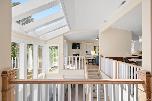 interior space featuring ceiling fan, hardwood / wood-style floors, and lofted ceiling with skylight