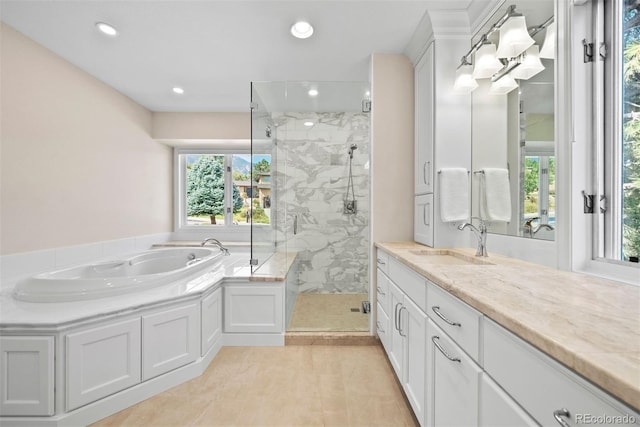 bathroom with tile patterned floors, vanity, and shower with separate bathtub