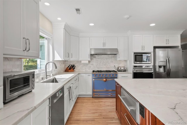 kitchen with light hardwood / wood-style flooring, sink, stainless steel appliances, light stone countertops, and white cabinets