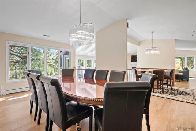 dining room with an inviting chandelier, a baseboard radiator, light wood-type flooring, and vaulted ceiling